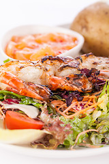 Image showing Grilled prawns with endive salad and jacket potato