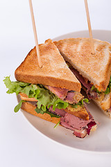 Image showing Delicious pastrami club sandwich and pickles