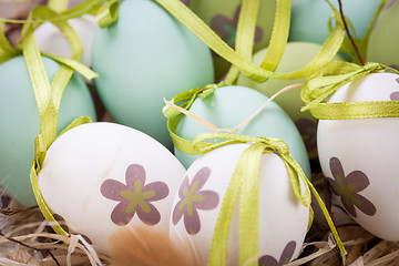 Image showing Colourful green Easter eggs in straw