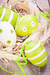 Image showing Colourful green Easter eggs in straw