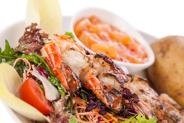 Image showing Grilled prawns with endive salad and jacket potato