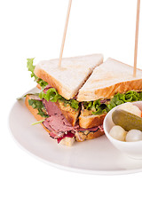 Image showing Delicious pastrami club sandwich and pickles