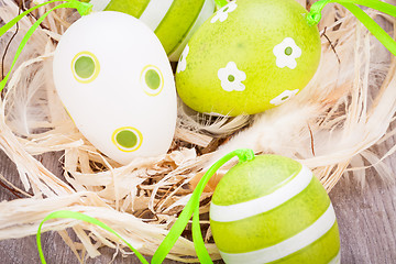 Image showing Colourful green Easter eggs in straw