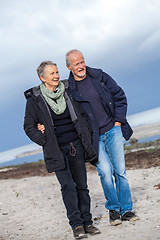 Image showing happy elderly senior couple walking on beach