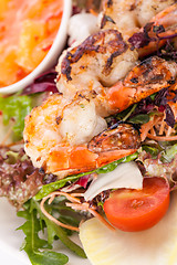 Image showing Grilled prawns with endive salad and jacket potato