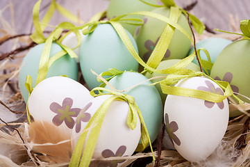 Image showing Colourful green Easter eggs in straw