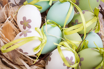 Image showing Colourful green Easter eggs in straw