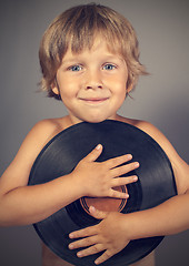 Image showing boy with a record smiles