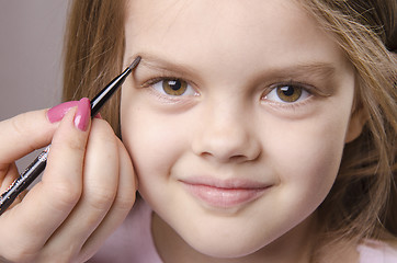 Image showing Makeup artist brings eyebrows on the girl's face