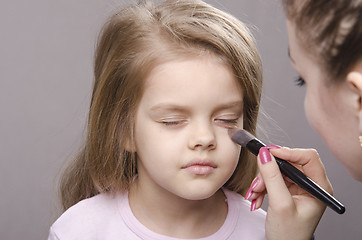 Image showing Makeup artist deals powder on face of girl