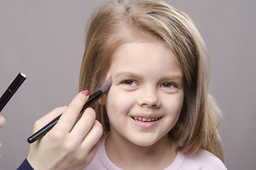 Image showing Makeup artist deals powder on face of girl