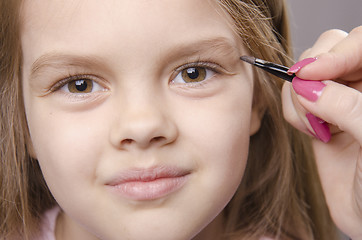 Image showing Makeup artist brings eyebrows on the girl's face