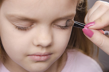 Image showing Makeup artist paints eyelids on girl's face