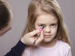 Image showing Makeup artist brings eyebrows on the girl's face