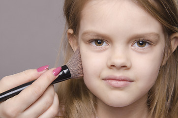 Image showing Makeup artist deals powder on face of girl