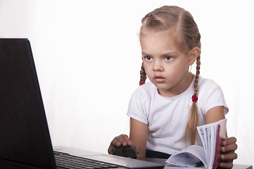 Image showing girl working at laptop, and records in notebook