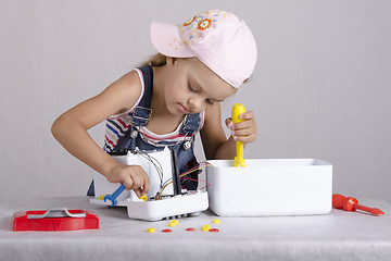Image showing Girl repairs toy small home appliances