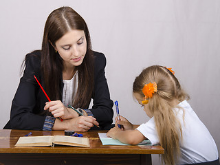 Image showing  teacher teaches lessons with student sitting at table