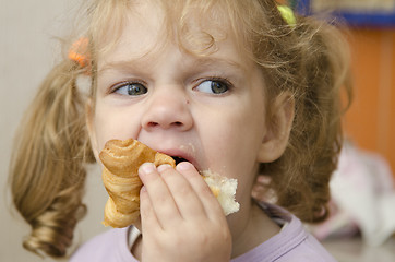 Image showing little girl with enthusiasm and eats roll pleasure