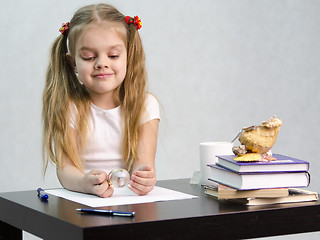 Image showing girl thoughtfully and effortlessly turns glass globe