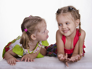 Image showing Two girls lie, one tongue, the other smiles