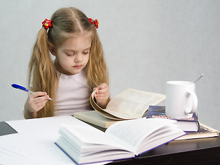 Image showing Girl leafing through book and wrote on a sheet of paper abstract sitting