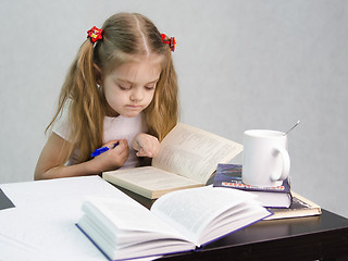 Image showing Girl leafing through book and wrote on a sheet of paper abstract sitting