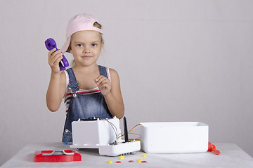 Image showing Girl repairs toy small home appliances