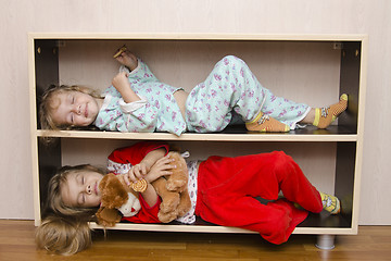 Image showing Two of children to lie on shelves, bedside tables