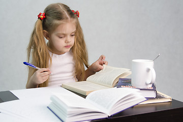 Image showing Girl leafing through book and wrote on a sheet of paper abstract sitting