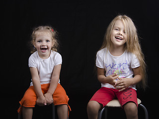Image showing Portrait of two young girls sitting on chairs