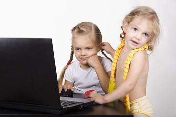 Image showing girl working at laptop. Another approached her and took