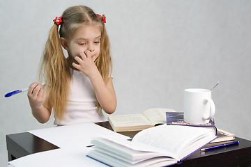 Image showing Girl leafing through book and wrote on a sheet of paper abstract sitting