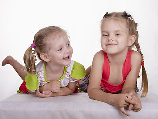 Image showing Two girls lie, one tongue, the other smiles