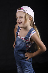 Image showing Portrait laughing four-year girl in overalls and cap