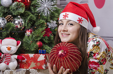 Image showing Girl with a large Christmas tree ball dreamily