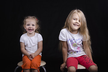 Image showing Portrait of two young girls sitting on chairs