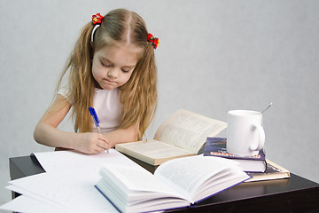 Image showing Girl leafing through book and wrote on a sheet of paper abstract sitting