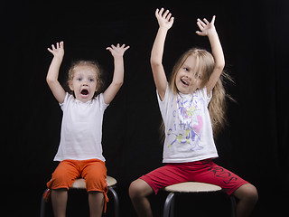 Image showing Two little girls raised their pens