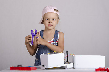 Image showing Girl repairs toy small home appliances