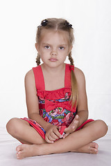 Image showing Girl in dress sits and stares out the frame