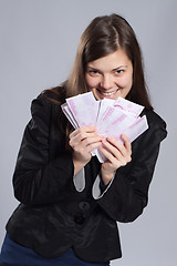 Image showing Young long-haired woman holding money