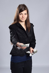 Image showing Young long-haired woman holding money