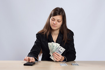 Image showing Young woman counts money