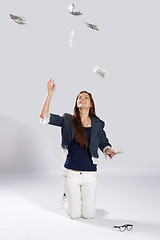 Image showing Young long-haired woman throw money