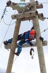 Image showing electrician working on top of an electricity pylon 