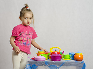 Image showing Girl plays child kitchen utensils