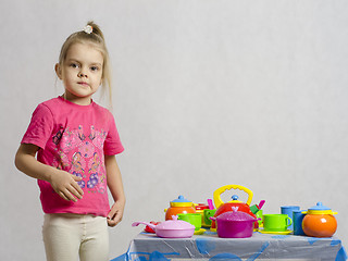 Image showing Girl plays child kitchen utensils