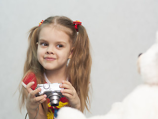 Image showing Girl takes photo of Teddy digital camera