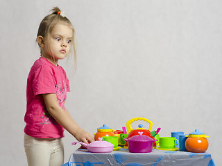 Image showing Girl plays child kitchen utensils